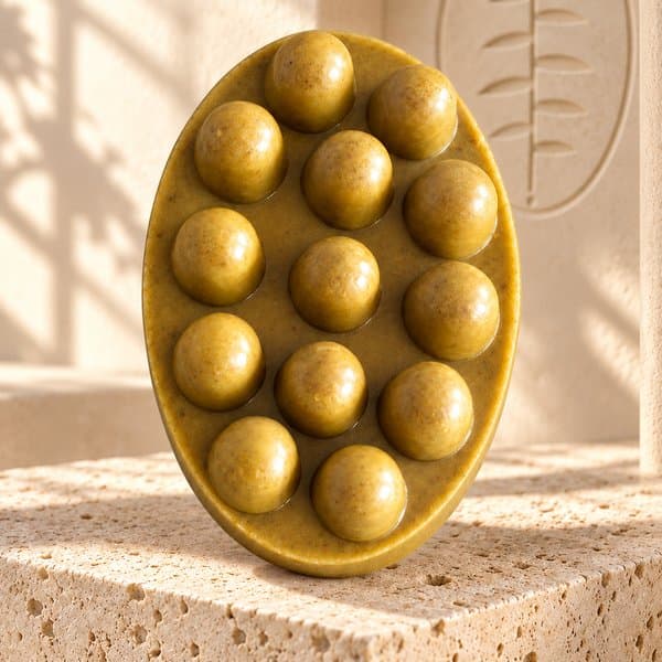 Organic Turmeric Soap on a stone plinth in the branded cream studio